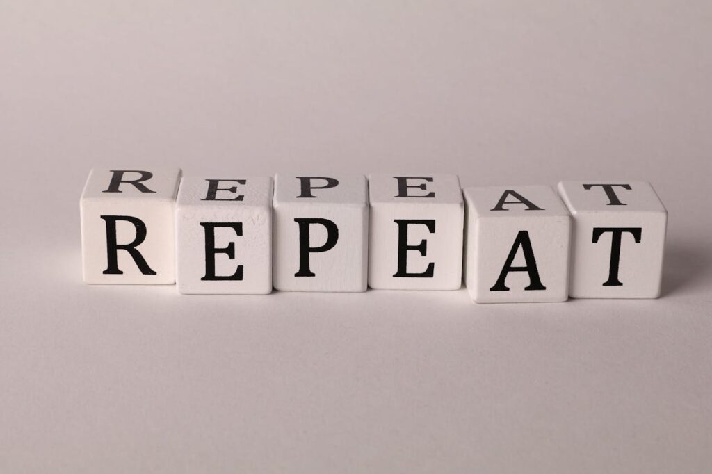 Scrabble tiles spelling the word “repeat,” representing how SiriusXM plays the same songs too often in business environments.