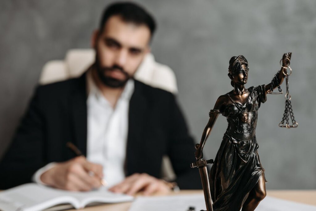 A lawyer in a suit sitting at a desk with legal scales, representing the importance of understanding music licensing laws for businesses.