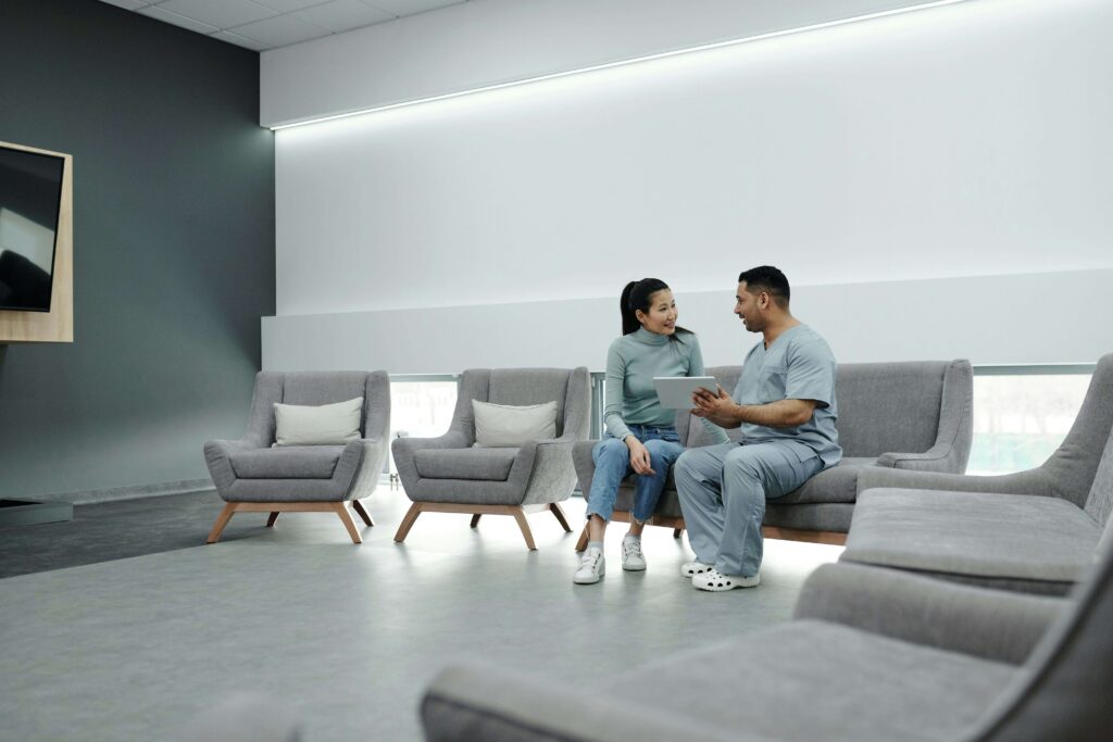 two individuals looking at device in waiting room
