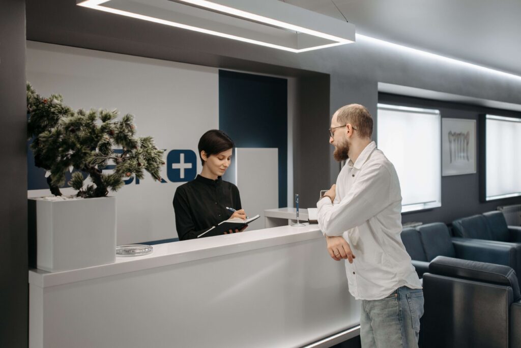 Patients seated in a modern medical office waiting room with comfortable seating, natural lighting, and a calm healthcare environment.